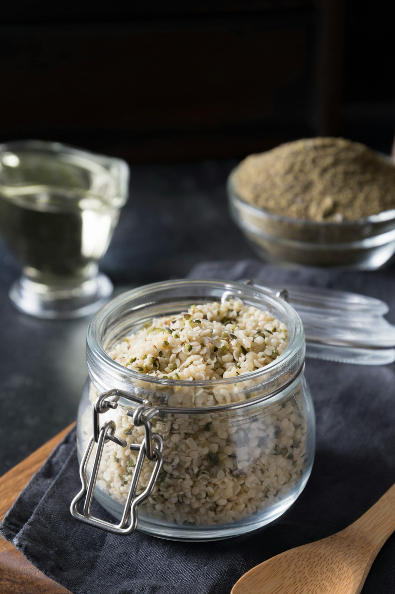 Organic kernels hemp in glass jar on black. Vertical format.